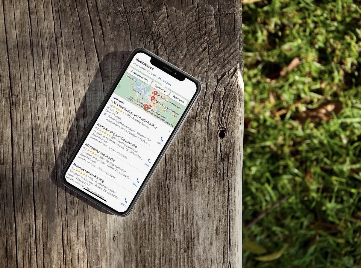 Smartphone showing Google local search results on a wooden deck